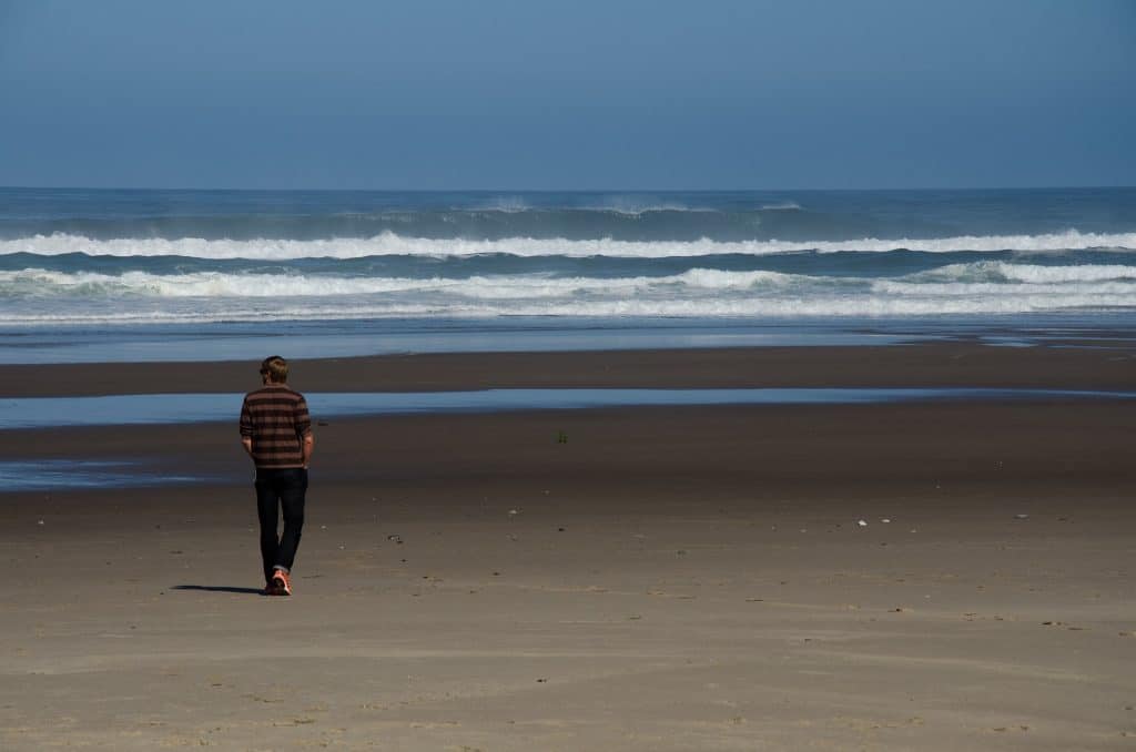 Hombre solo caminando por la playa. COMO CREAR LA REALIDAD QUE TU DESEAS