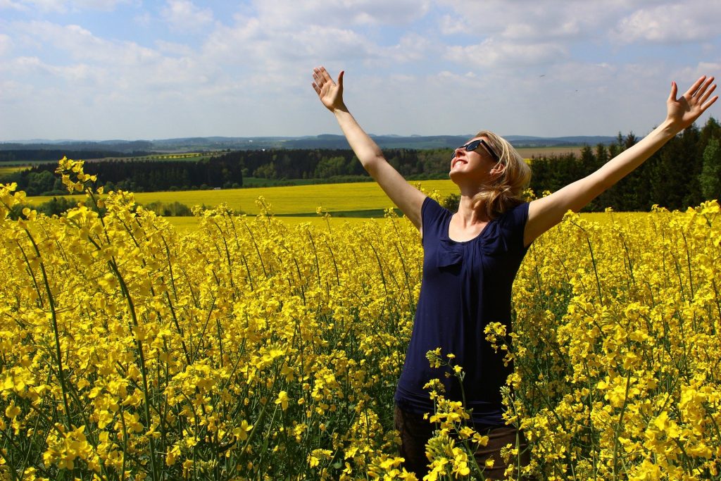 Mujer alegre en un jardín. COMO CREAR LA REALIDAD QUE TU DESEAS